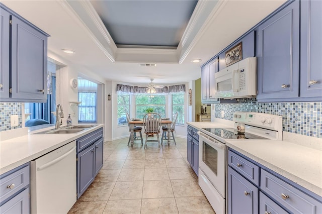 kitchen featuring backsplash, ornamental molding, white appliances, a tray ceiling, and sink