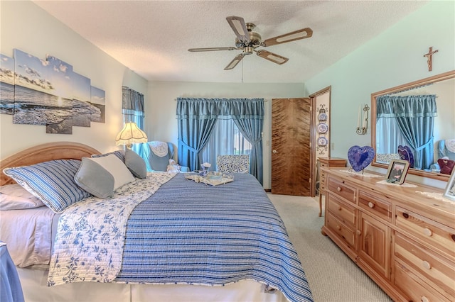 carpeted bedroom with ceiling fan and a textured ceiling