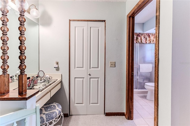 bathroom with tile patterned floors, a shower, and toilet