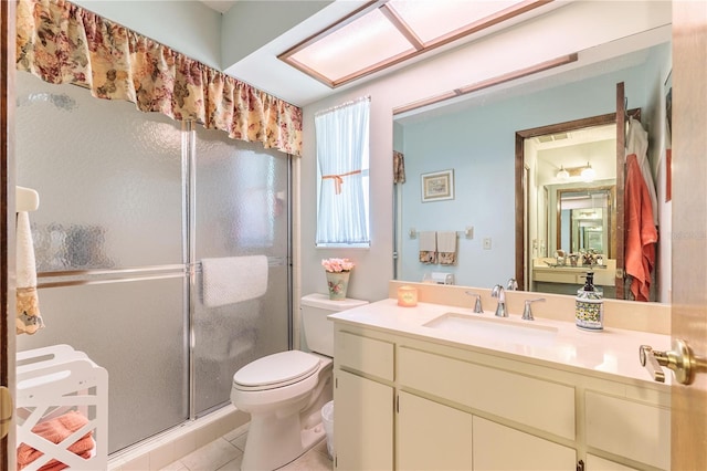 bathroom featuring tile patterned flooring, vanity, toilet, and a shower with shower door