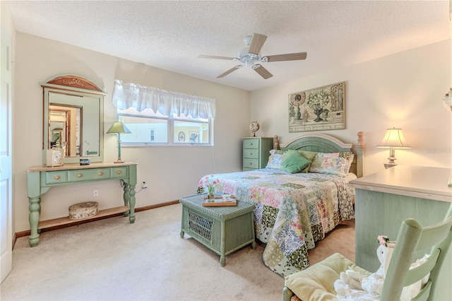 carpeted bedroom featuring ceiling fan and a textured ceiling