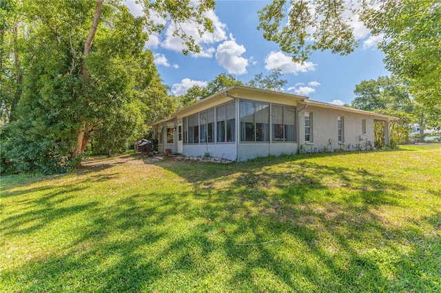 view of side of home with a sunroom and a yard