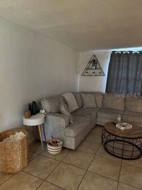 tiled living room featuring a textured ceiling