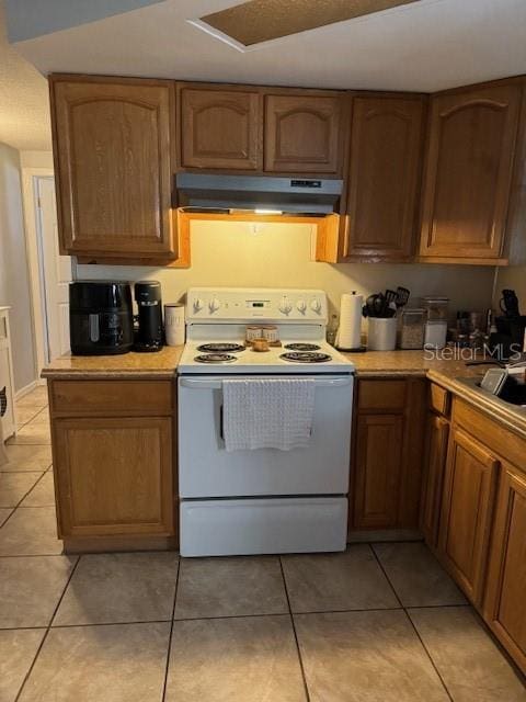 kitchen featuring light tile floors, sink, and white electric range