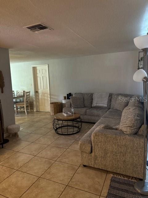 living room featuring tile floors and a textured ceiling