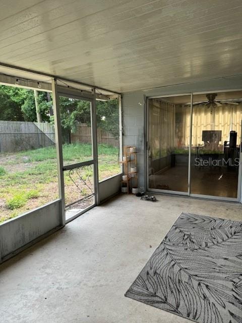 unfurnished sunroom with ceiling fan