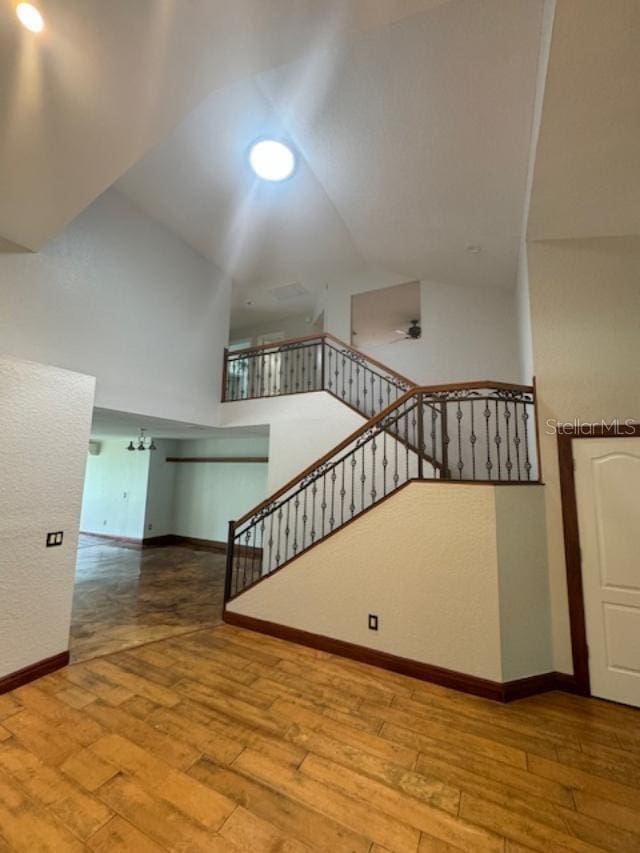 staircase with wood-type flooring and vaulted ceiling