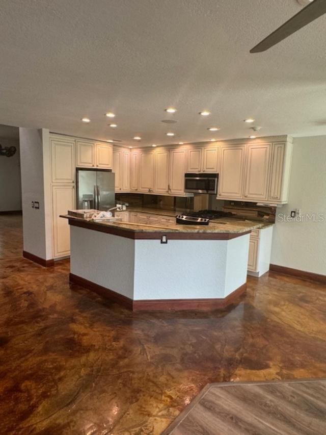 kitchen with white cabinets, a center island with sink, dark hardwood / wood-style flooring, appliances with stainless steel finishes, and a textured ceiling