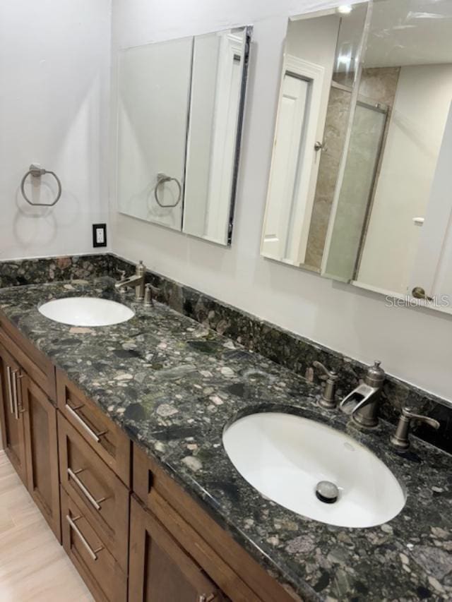 bathroom featuring vanity, hardwood / wood-style flooring, and a shower with shower door