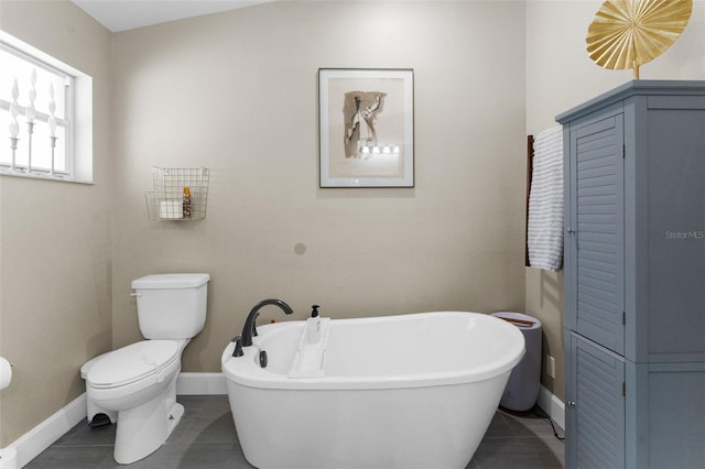 bathroom featuring tile patterned floors, toilet, and a bath