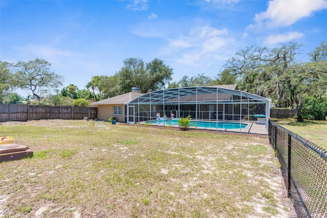 view of yard with glass enclosure and a fenced in pool