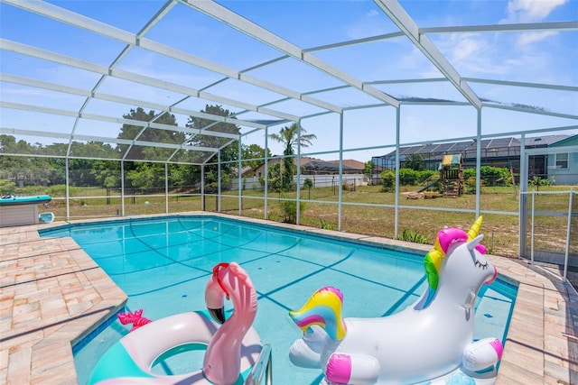 view of pool with a yard and glass enclosure