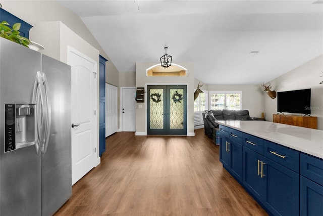 kitchen featuring stainless steel refrigerator with ice dispenser, wood-type flooring, french doors, and blue cabinets