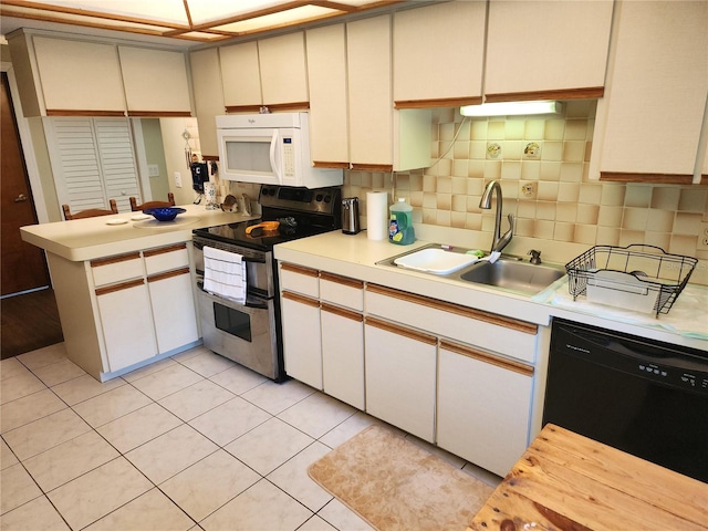 kitchen featuring kitchen peninsula, tasteful backsplash, dishwasher, range with two ovens, and sink