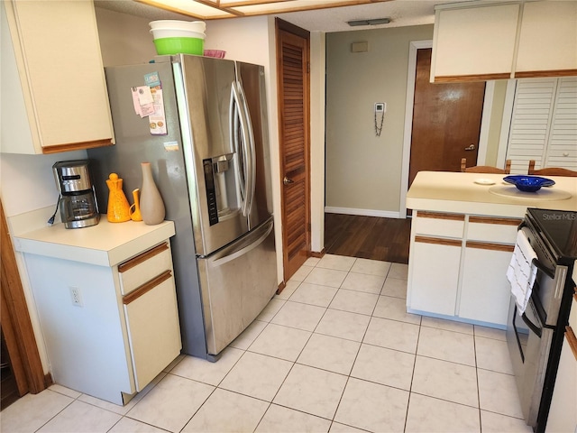 kitchen featuring range with electric stovetop, stainless steel refrigerator with ice dispenser, light wood-type flooring, and white cabinetry