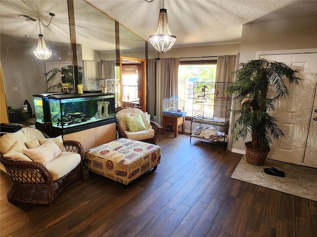 living room with an inviting chandelier, a textured ceiling, and hardwood / wood-style flooring