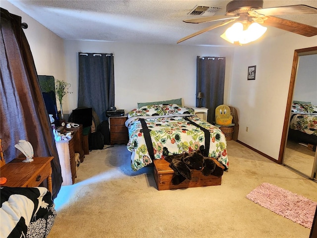 carpeted bedroom with a textured ceiling and ceiling fan