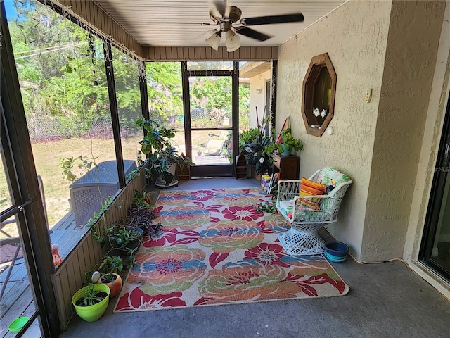 unfurnished sunroom featuring ceiling fan