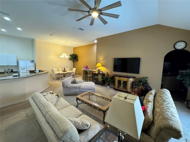 carpeted living room featuring vaulted ceiling and ceiling fan with notable chandelier