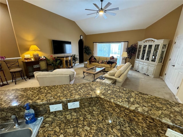 carpeted living room featuring ceiling fan and lofted ceiling