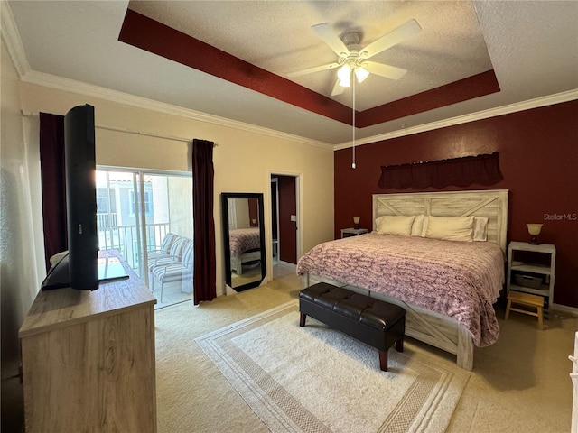 bedroom featuring light carpet, ceiling fan, access to exterior, a textured ceiling, and a tray ceiling