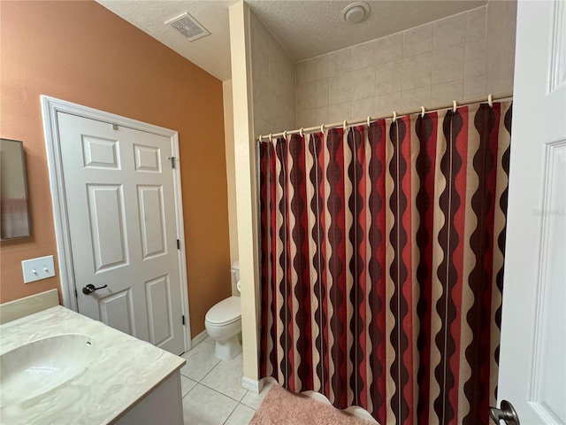 bathroom featuring tile patterned flooring, vanity, a textured ceiling, and toilet