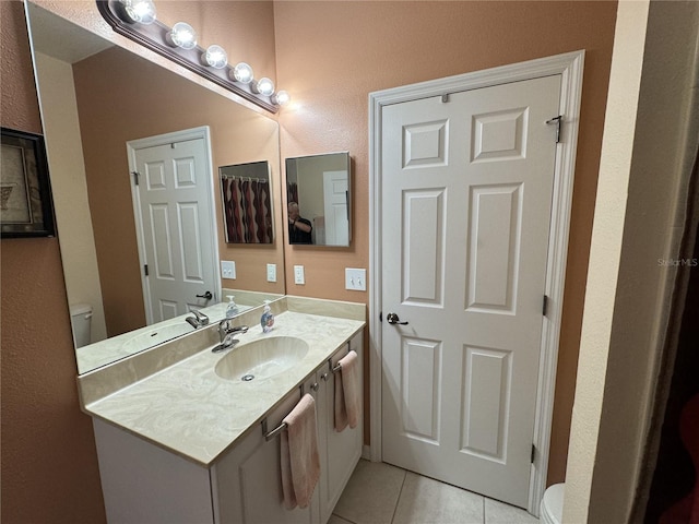 bathroom with tile patterned floors, vanity, and toilet