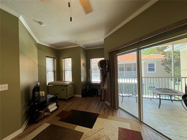 doorway to outside featuring hardwood / wood-style flooring, ceiling fan, ornamental molding, and a textured ceiling