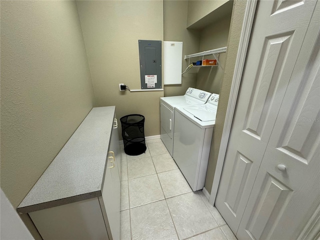 laundry room featuring light tile patterned floors, electric panel, and washing machine and clothes dryer