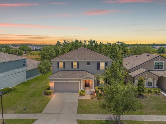 view of front of home with a yard and a garage