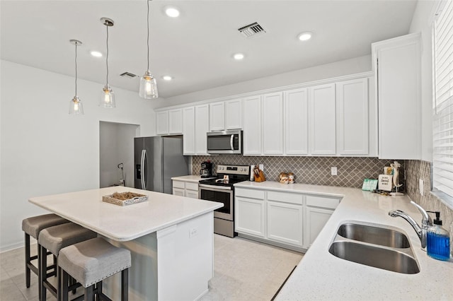 kitchen featuring decorative light fixtures, light tile floors, backsplash, and appliances with stainless steel finishes