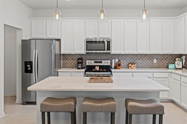 kitchen featuring stainless steel appliances, white cabinets, light tile flooring, and backsplash