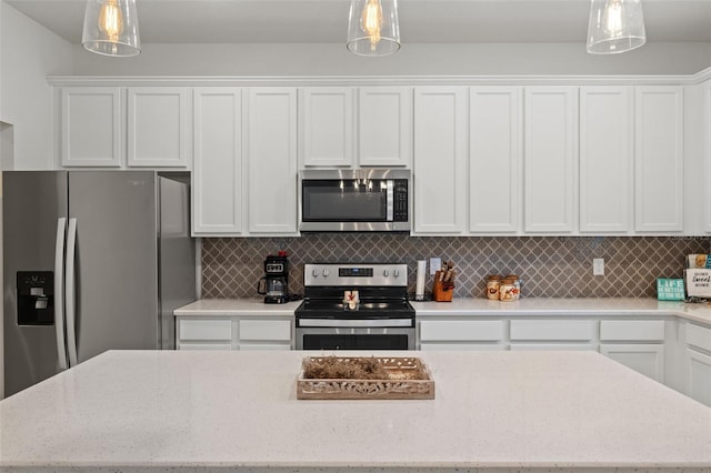 kitchen featuring appliances with stainless steel finishes, white cabinetry, and pendant lighting