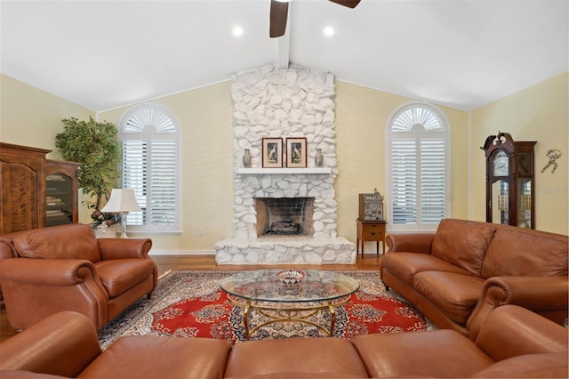 living room with a stone fireplace, lofted ceiling with beams, ceiling fan, and wood-type flooring