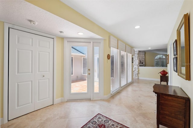 doorway featuring a textured ceiling, light tile patterned floors, and a fireplace