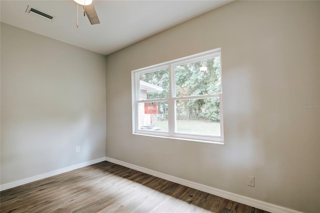 empty room featuring ceiling fan, baseboards, wood finished floors, and visible vents