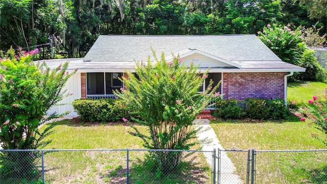 view of front of house with a gate, brick siding, a front yard, and fence private yard