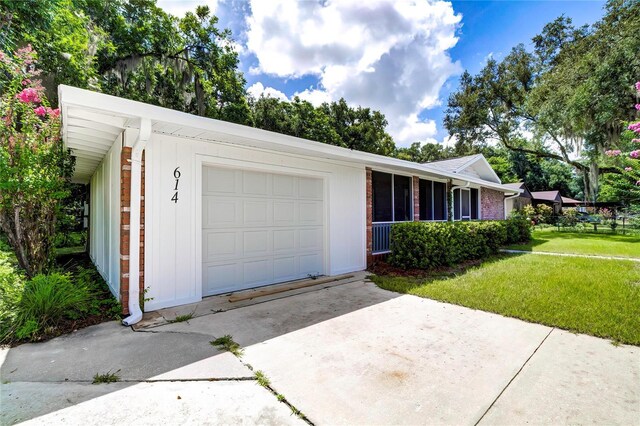 ranch-style home with brick siding, a front lawn, driveway, and a garage