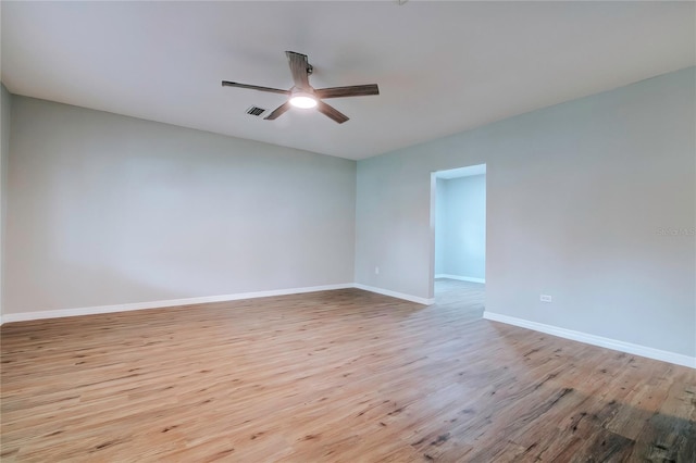 spare room with visible vents, a ceiling fan, baseboards, and light wood-style floors
