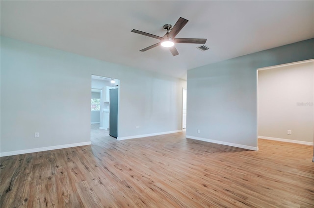 empty room with ceiling fan and light hardwood / wood-style flooring