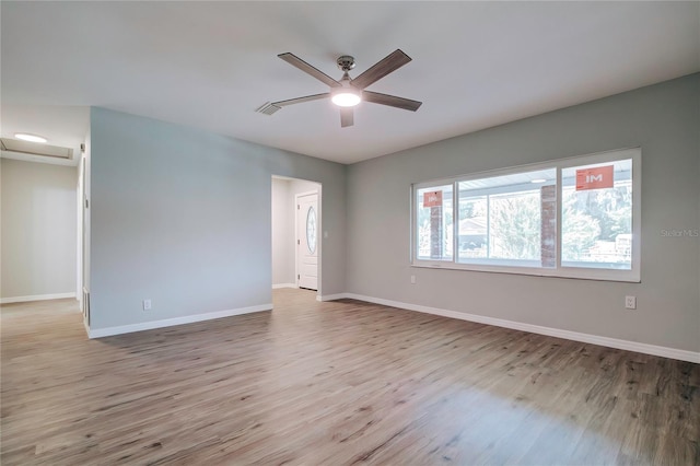 unfurnished room with ceiling fan, baseboards, wood finished floors, and visible vents