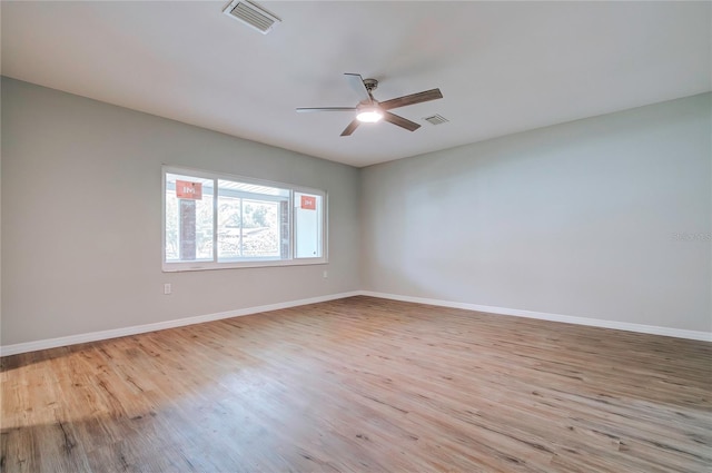 empty room with ceiling fan, baseboards, light wood-style floors, and visible vents