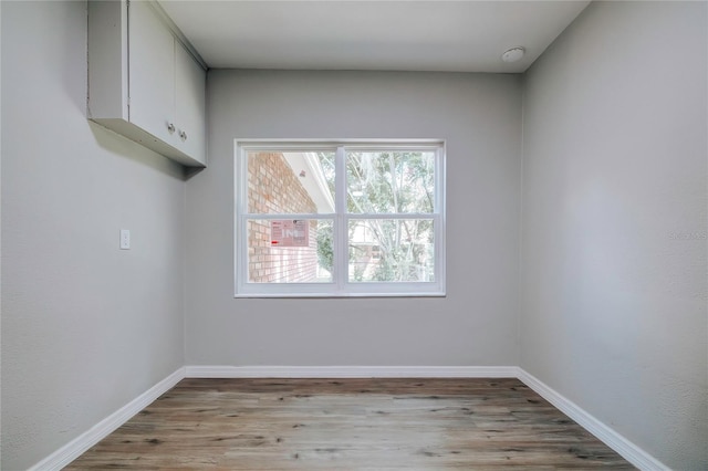 unfurnished room featuring baseboards and light wood-type flooring
