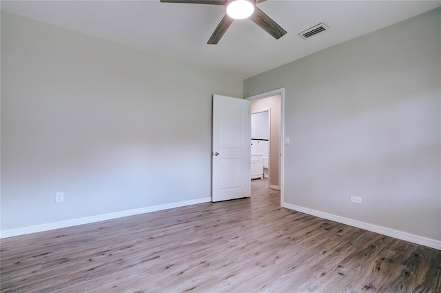 unfurnished room with wood finished floors, visible vents, baseboards, and ceiling fan
