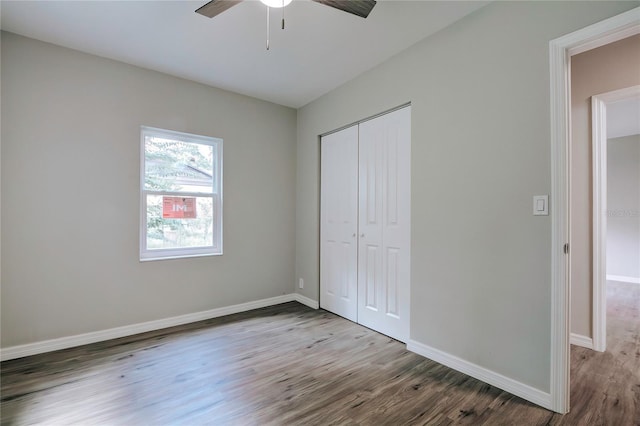 unfurnished bedroom with wood finished floors, a closet, baseboards, and ceiling fan
