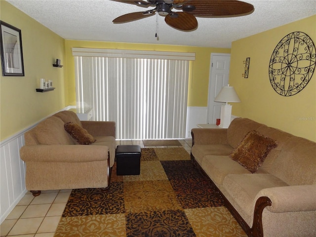 living room featuring light tile patterned floors, a textured ceiling, and ceiling fan