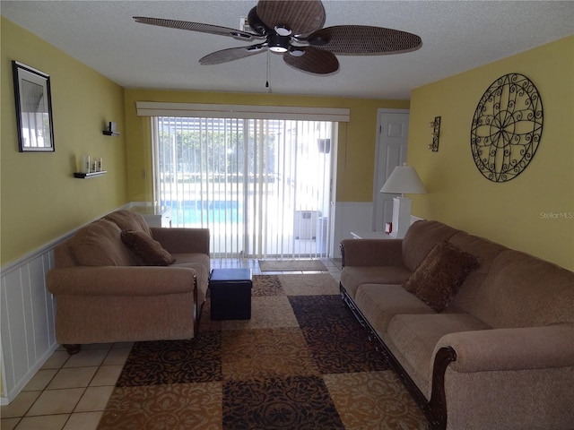 tiled living room featuring a textured ceiling and ceiling fan