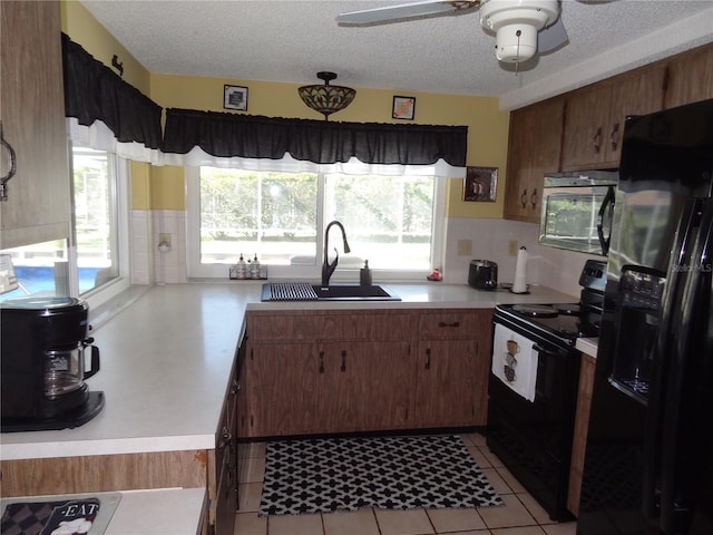 kitchen featuring black appliances, ceiling fan, sink, and a textured ceiling