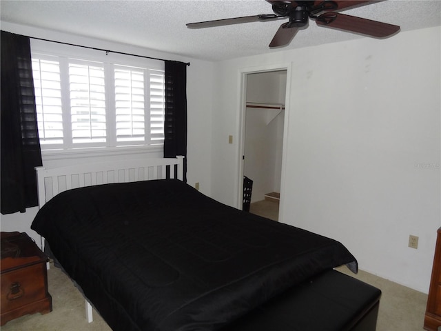 bedroom featuring radiator, ceiling fan, a spacious closet, a textured ceiling, and a closet