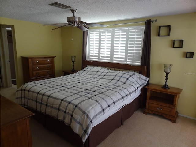 carpeted bedroom with a textured ceiling and ceiling fan